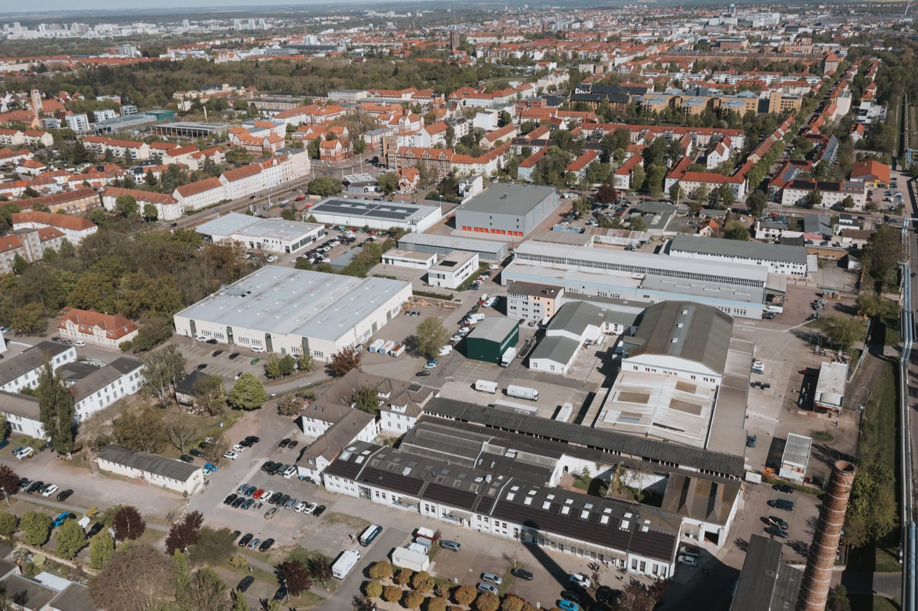 Drohnenblick über den Gewerbepark und die rot gedeckten Wohnviertel von Halle (Saale)