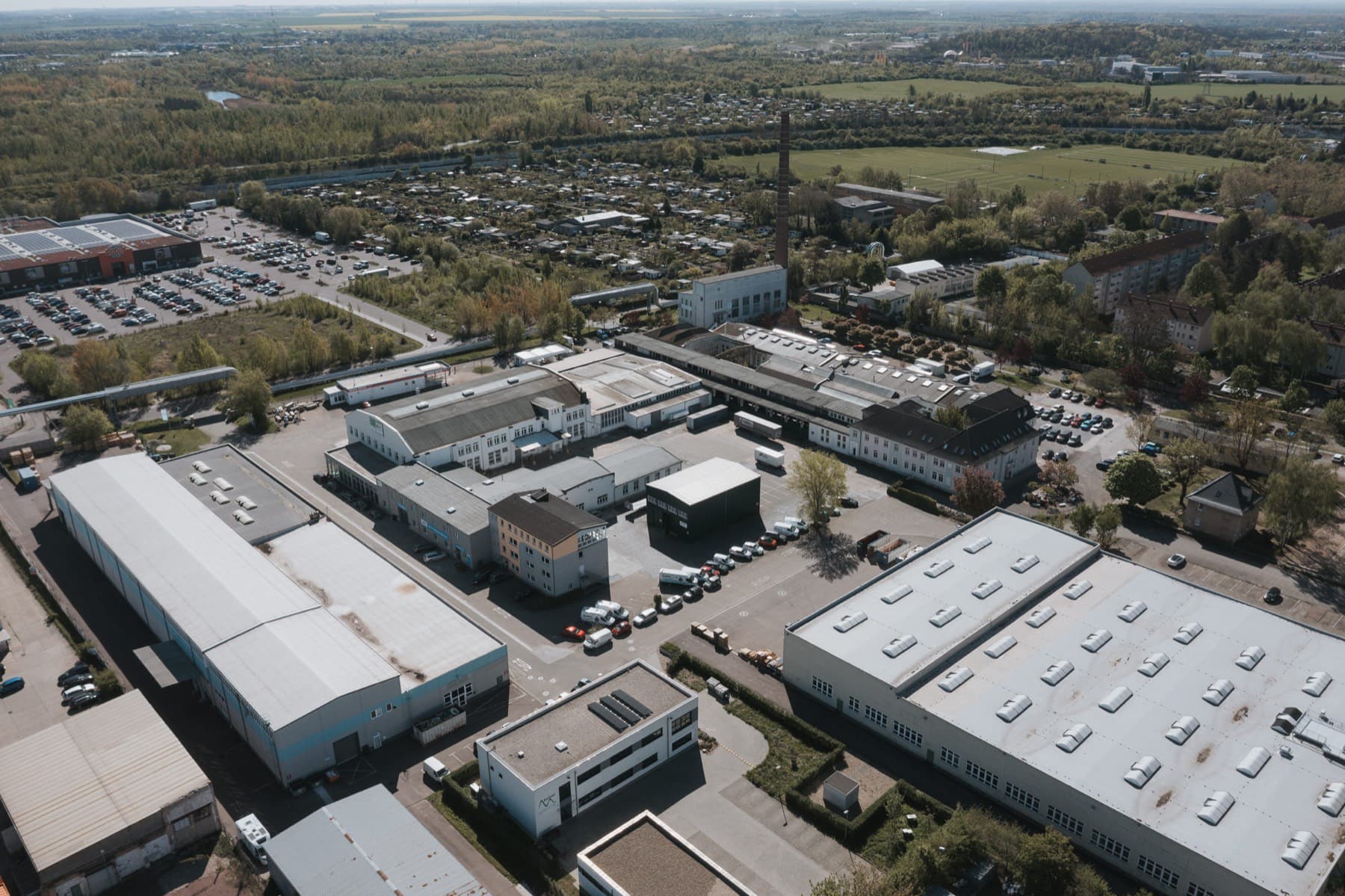Drohnenblick auf die Innenhöfe des Gewerbeparks, im Hintergrund Felder und Grünflächen
