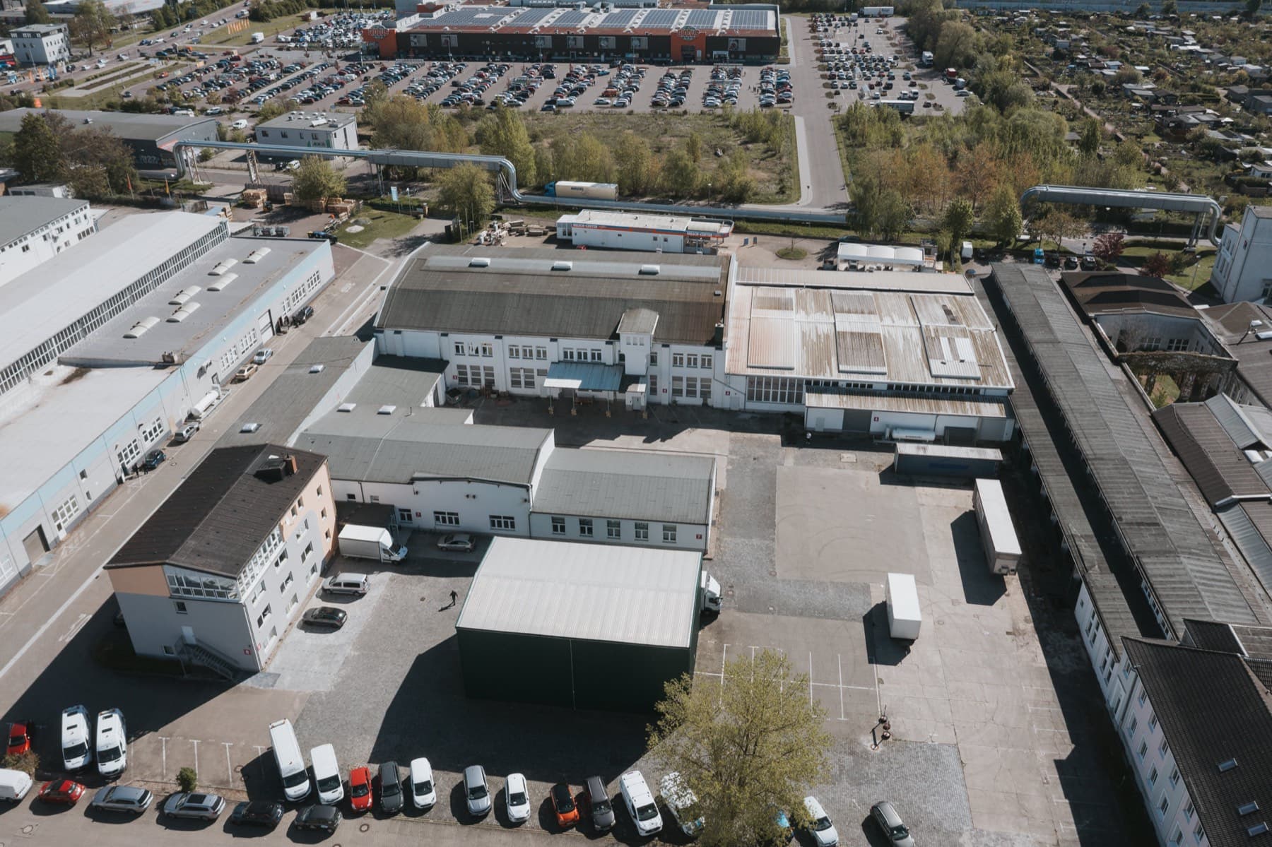 Drohnenaufnahme der Hallendächer mit Innenhof und Wasch-Center am Rand des Gewerbeparks