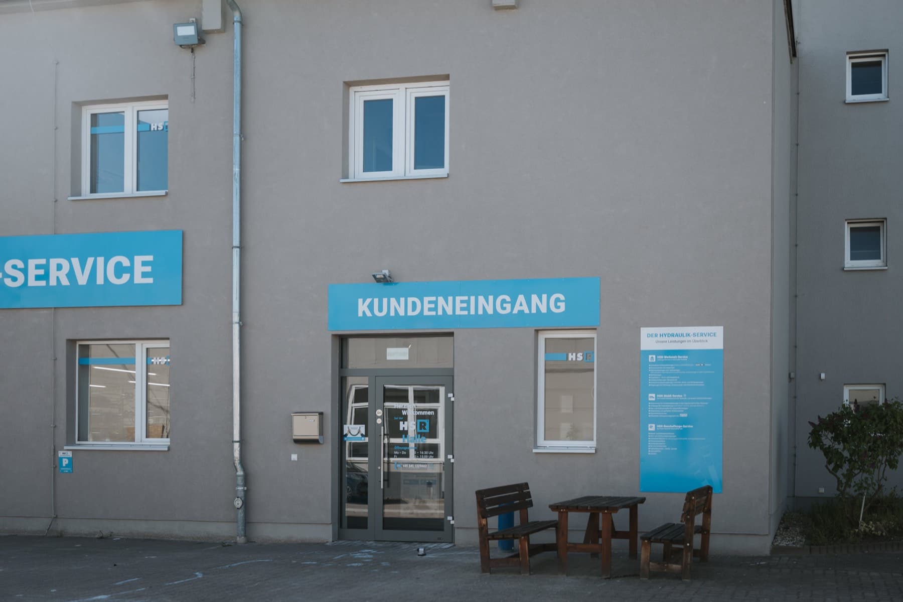 Kundeneingang von Gebäude 6 mit Sitzgruppe und Leistungsübersicht am Gebäude
