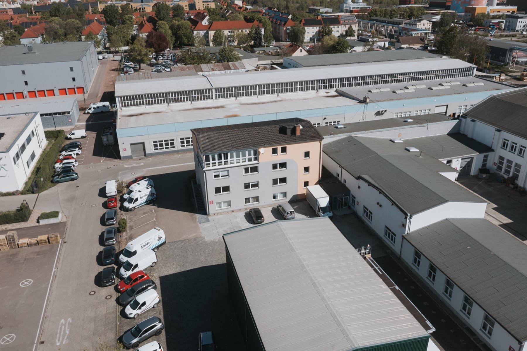 Drohnenaufnahme des Bürogebäudes 8 inmitten des Gewerbeparks mit umliegenden Hallen