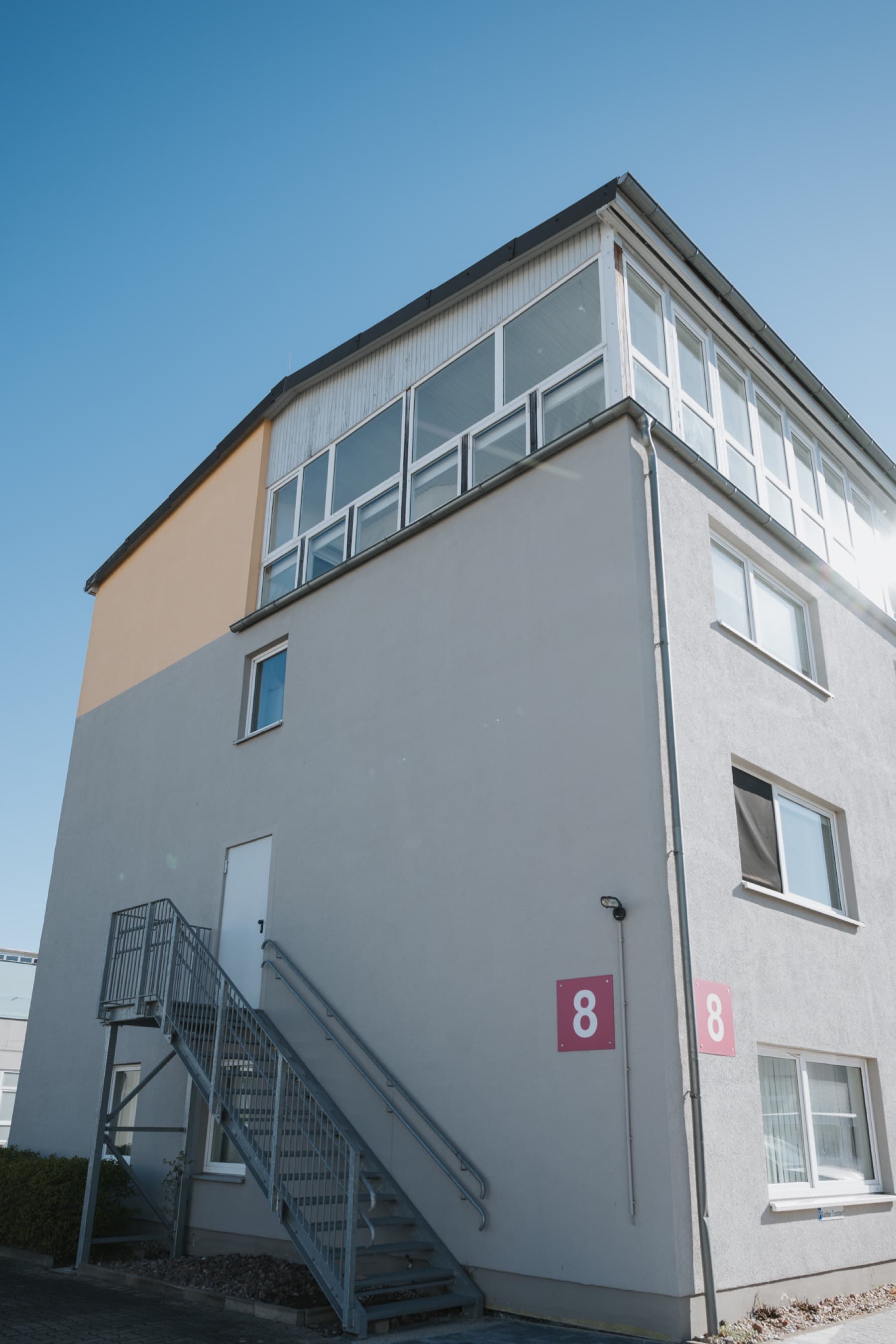 Gebäude 8 von unten mit verglaster Dachetage und Außentreppe