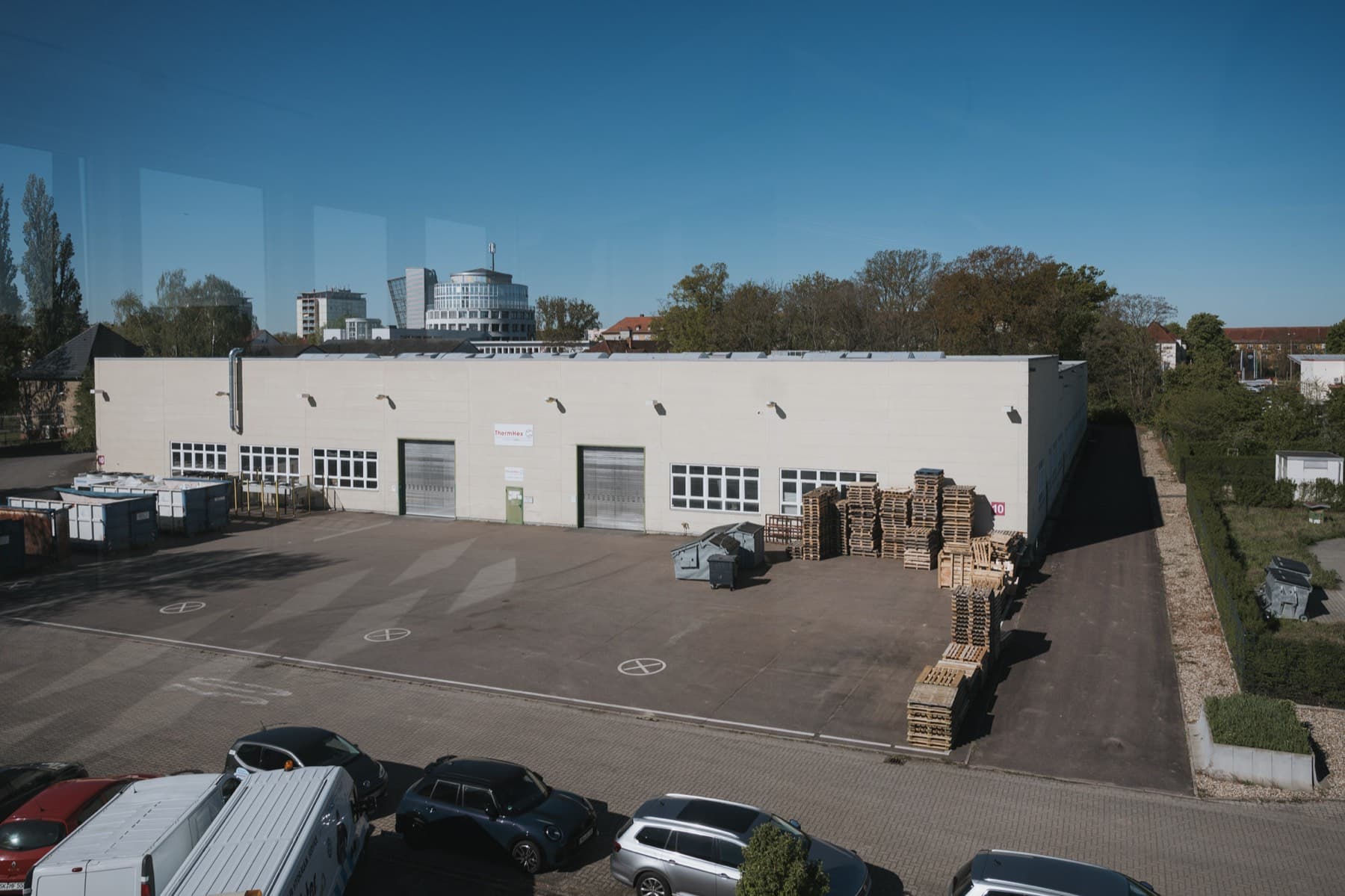 Blick aus Gebäude 8 auf den Hof vor Halle 10 mit der Skyline von Halle im Hintergrund