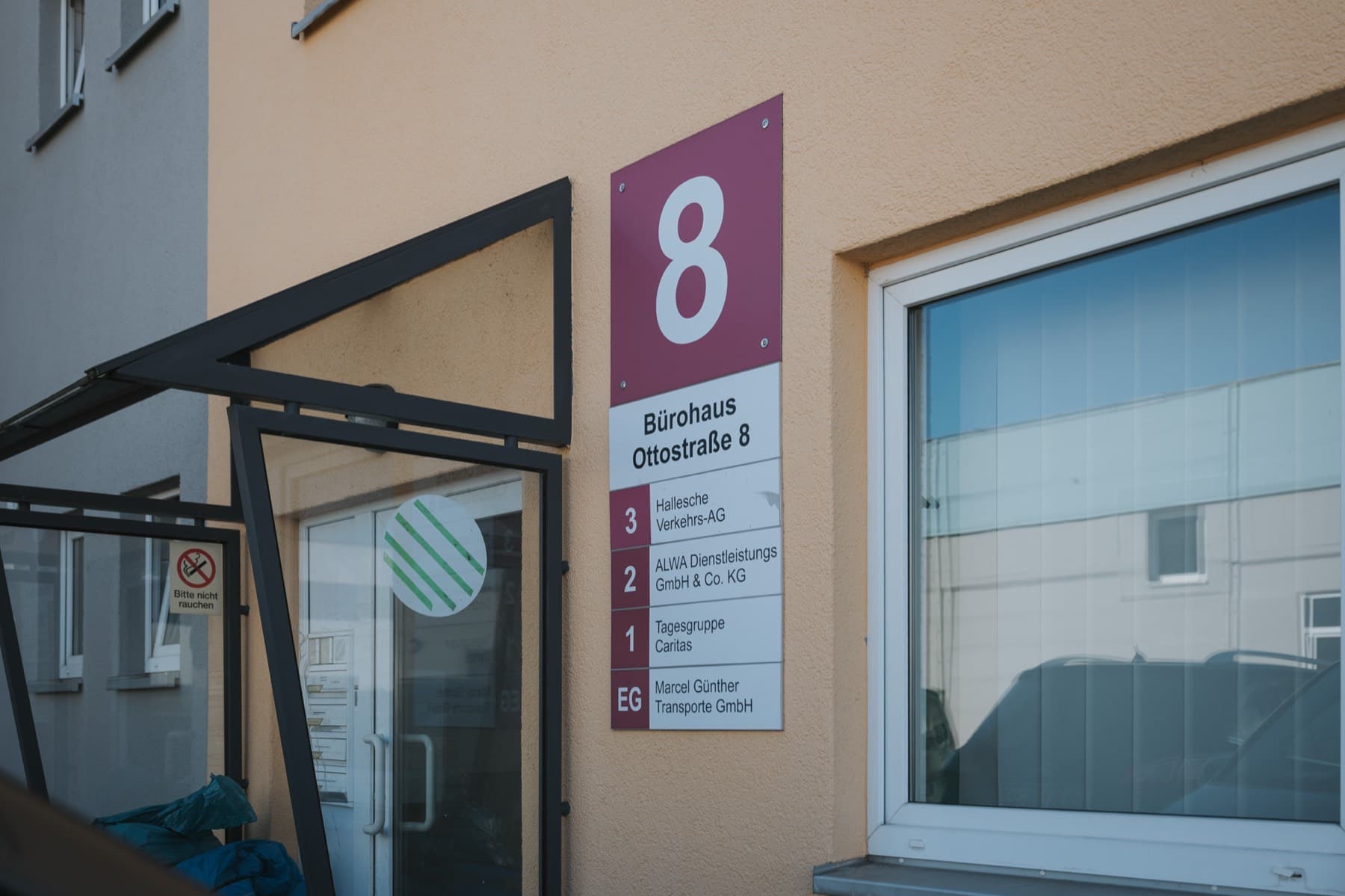 Eingang zum Bürohaus Ottostraße 8 mit Mieterverzeichnis am Schild