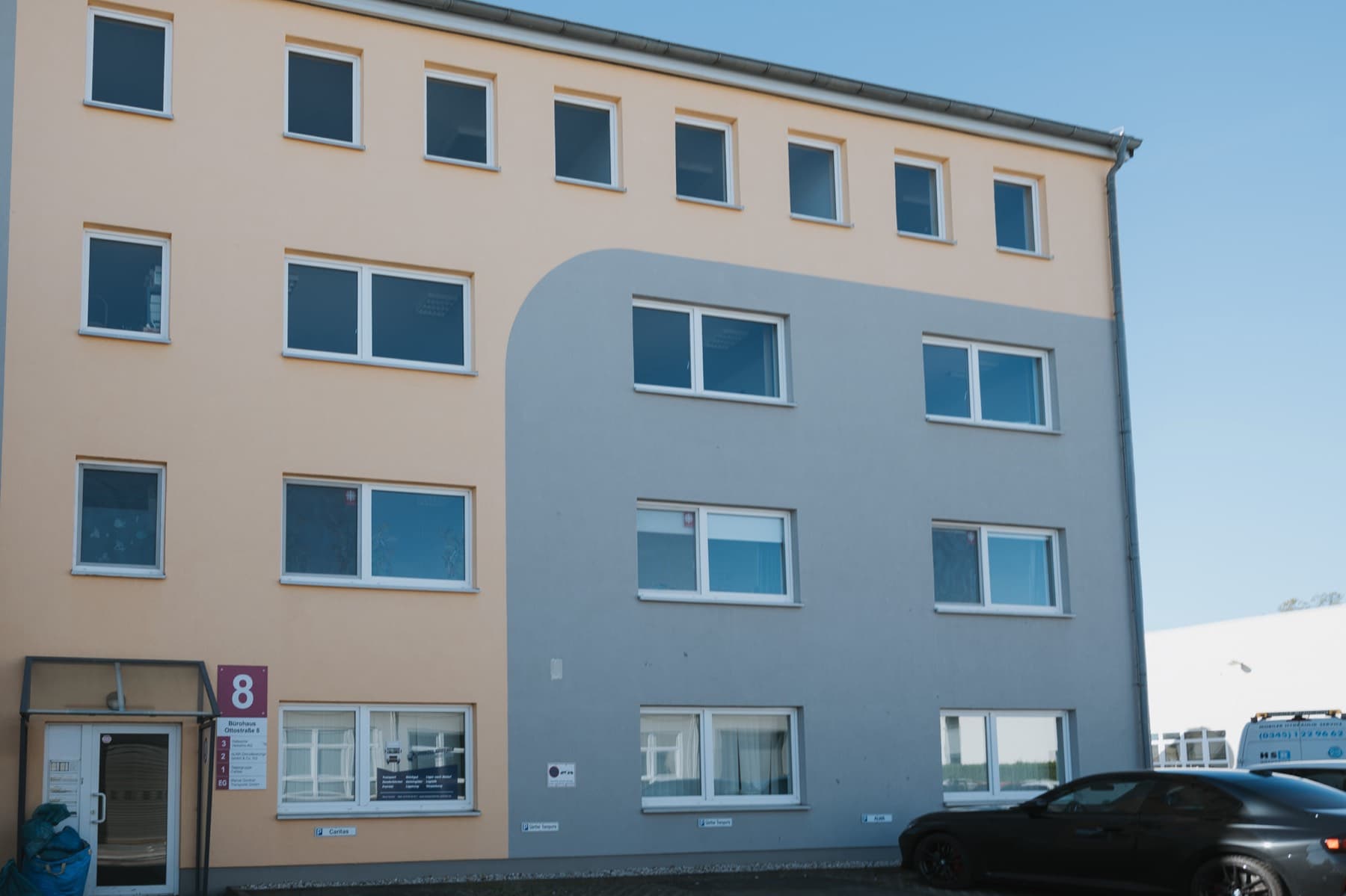 Fassade des Bürohauses Ottostraße 8 in Orange und Grau mit Hausnummer 8