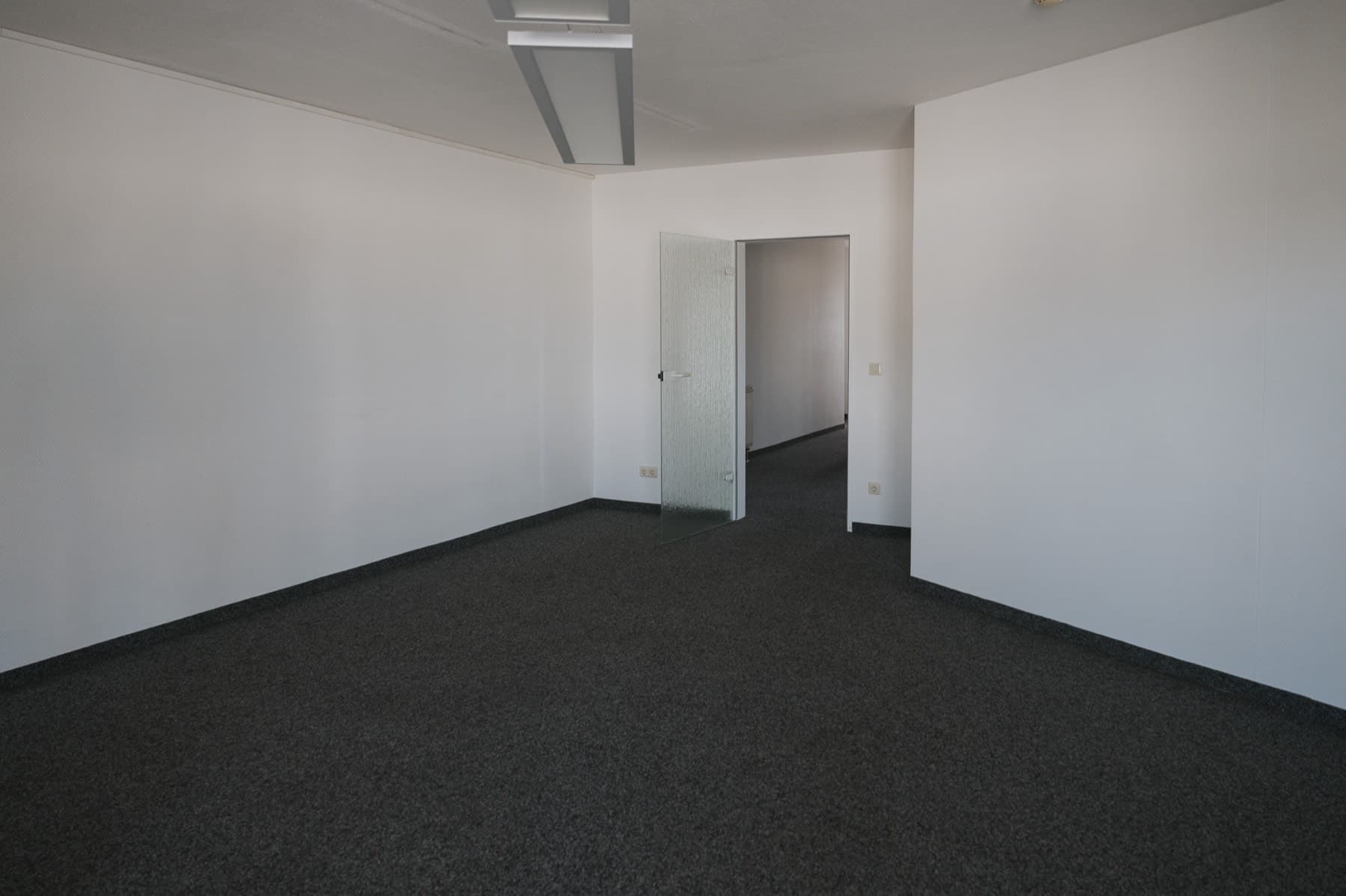 Heller Büroraum mit Teppichboden und Glastür im Gebäude 8