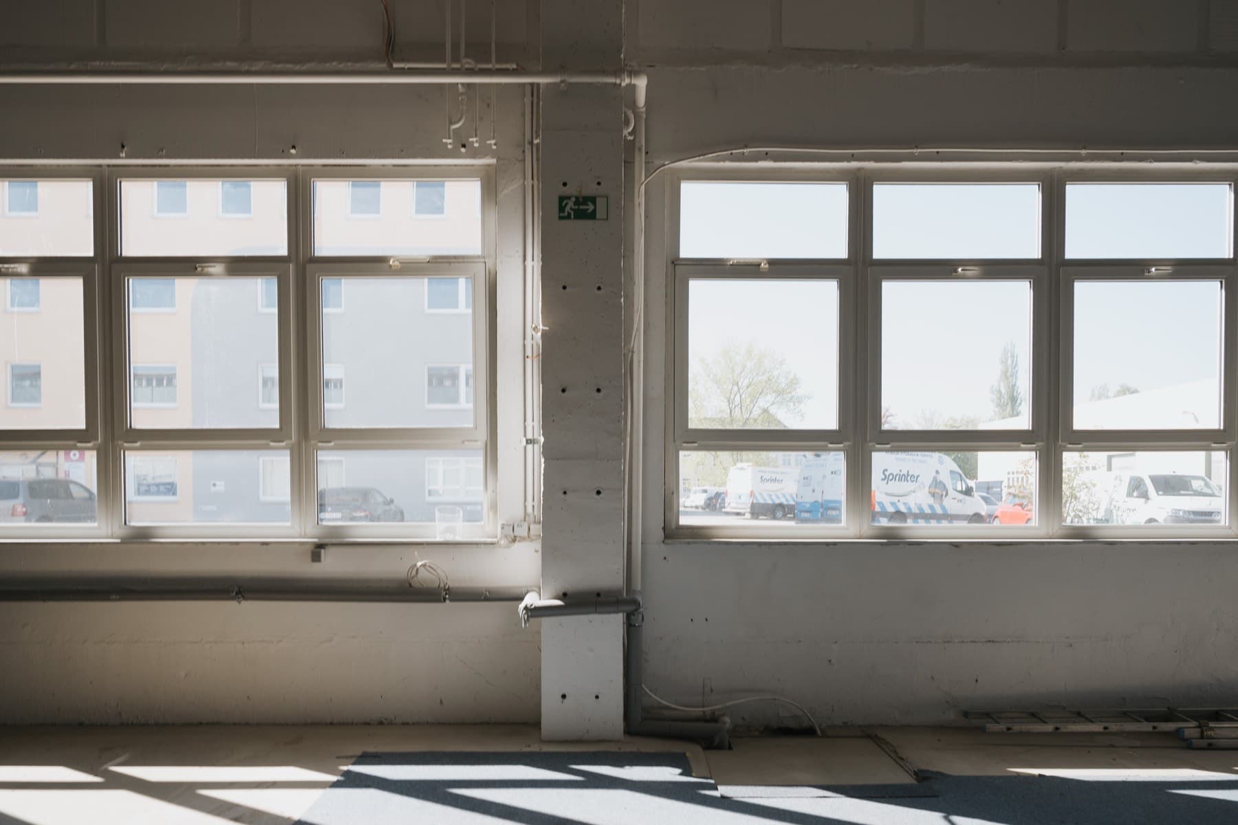 Halle 1 — Fensterfront von innen mit Tageslicht und Blick auf den Parkplatz