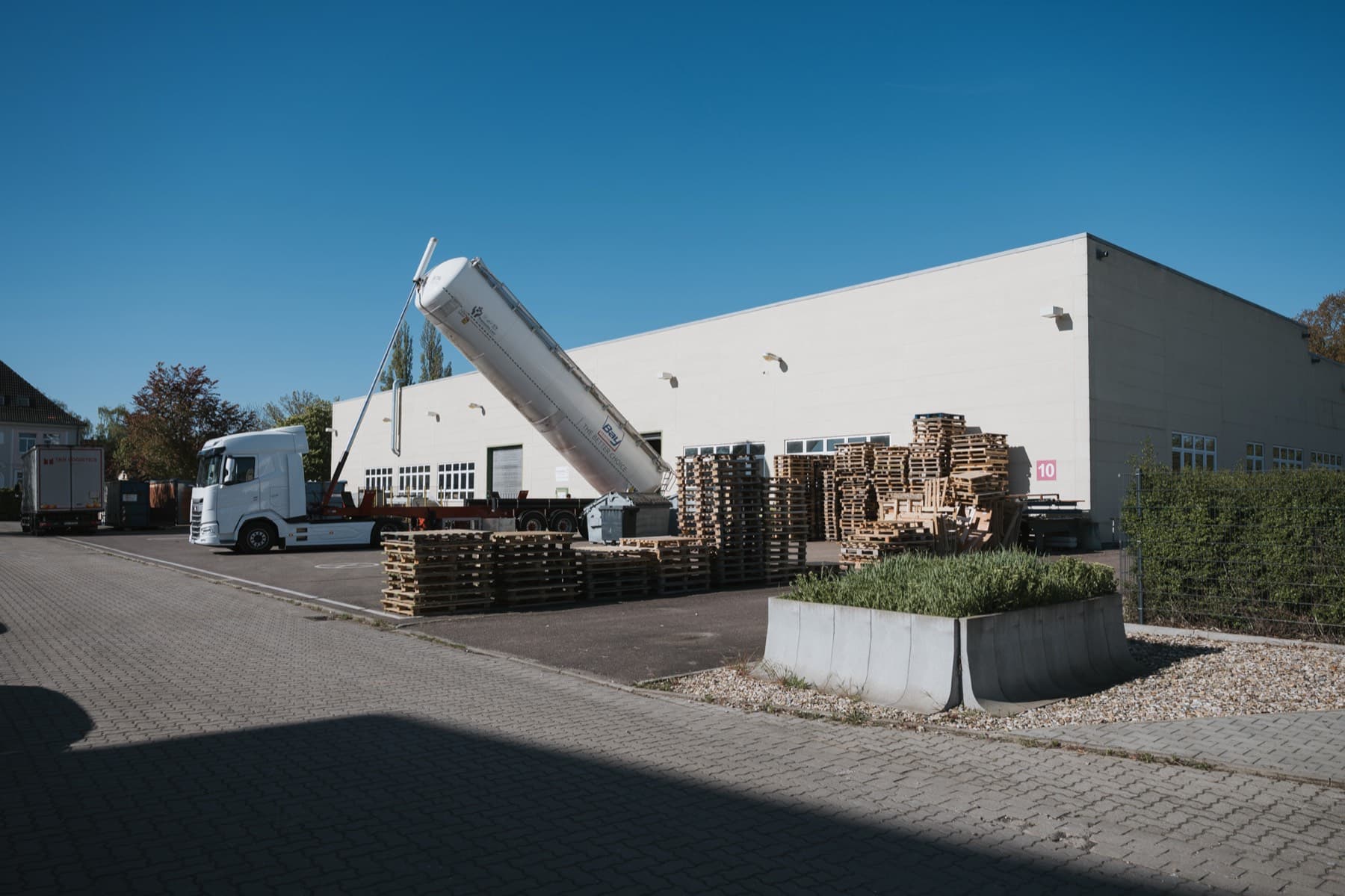 Silo-Lkw und Palettenlager an der Anlieferung der Halle 10