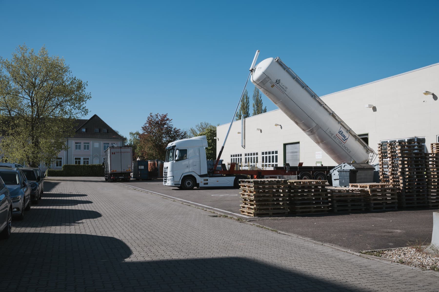 Silo-Lkw mit aufgestelltem Auflieger vor der Halle 10, im Hintergrund das Nachbargebäude