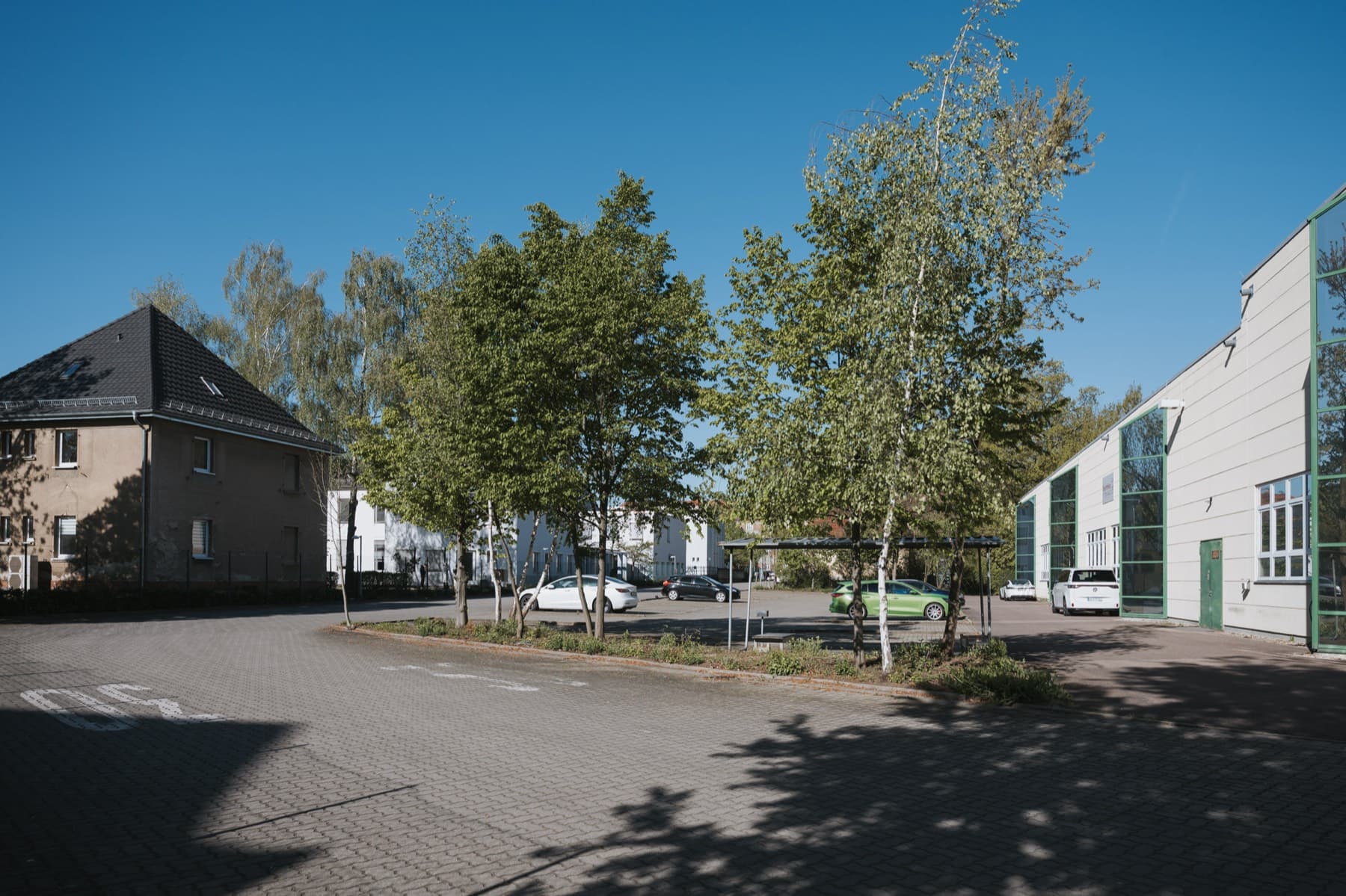 Begrünter Parkplatz mit Bäumen vor der Halle 10