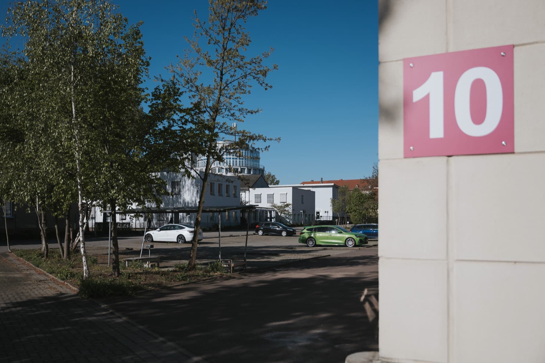 Hallennummer 10 an der Fassade, im Hintergrund Parkplatz und Bürogebäude