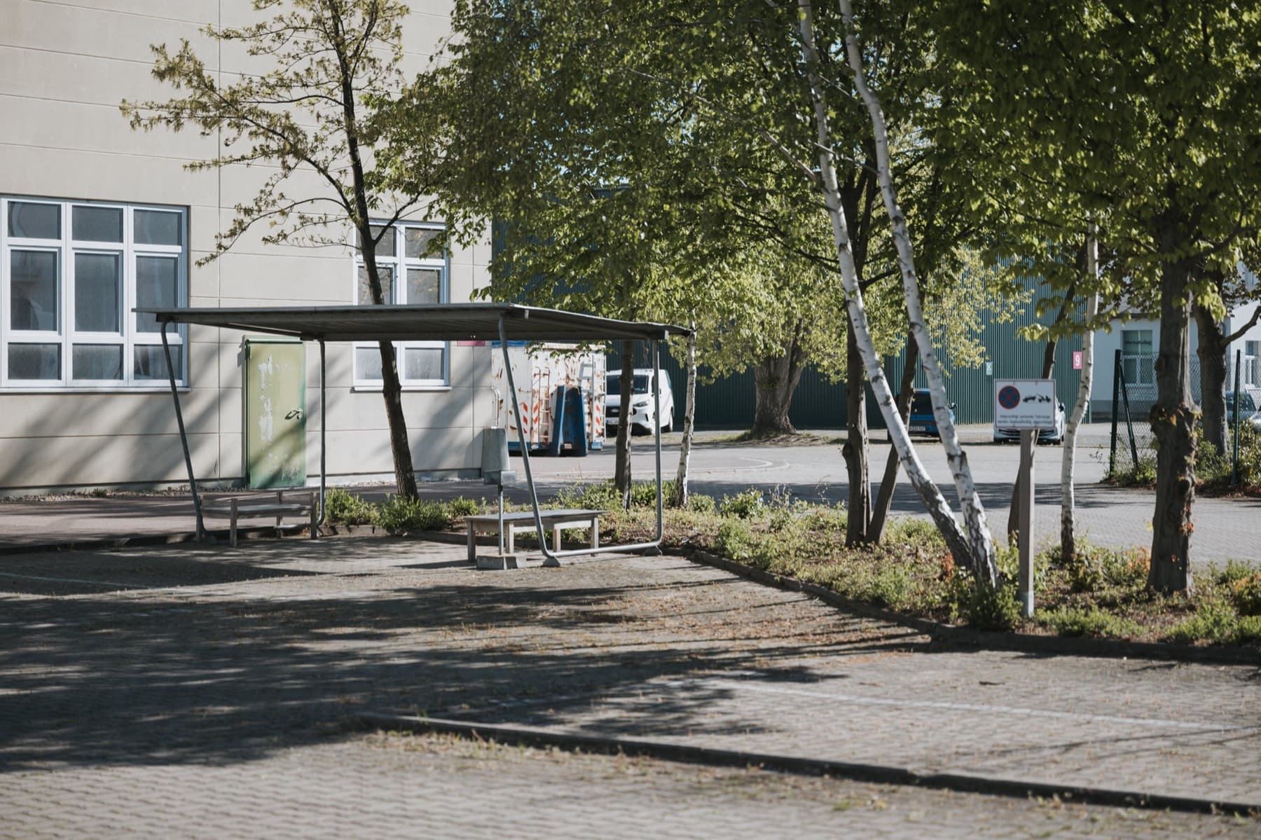 Überdachte Sitzecke mit Bänken vor der Halle 10