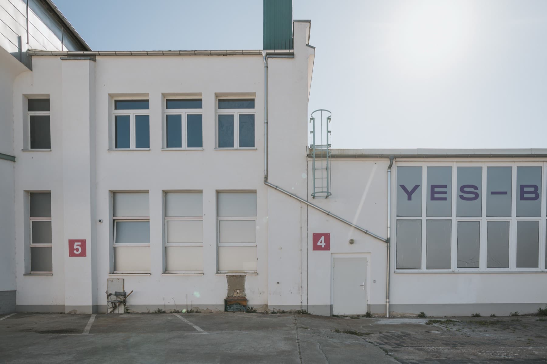 Außenansicht der Halle 4 mit Fensterband und Rolltor