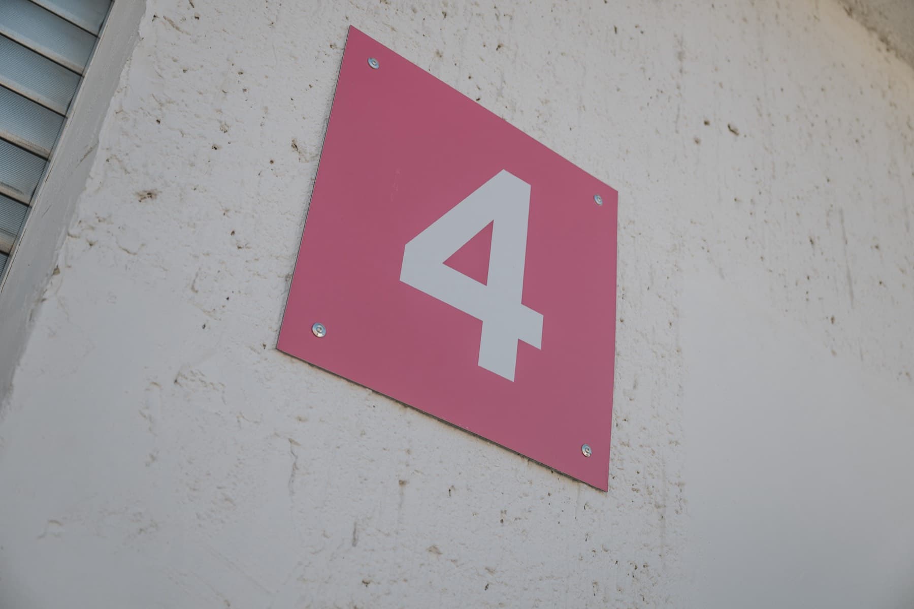 Rotes Hallenschild mit der Nummer 4 an der Fassade