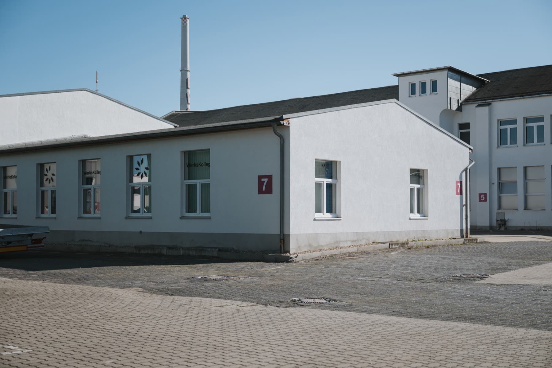 Halle 7 mit WerksKolleg, dahinter der Backstein-Schornstein