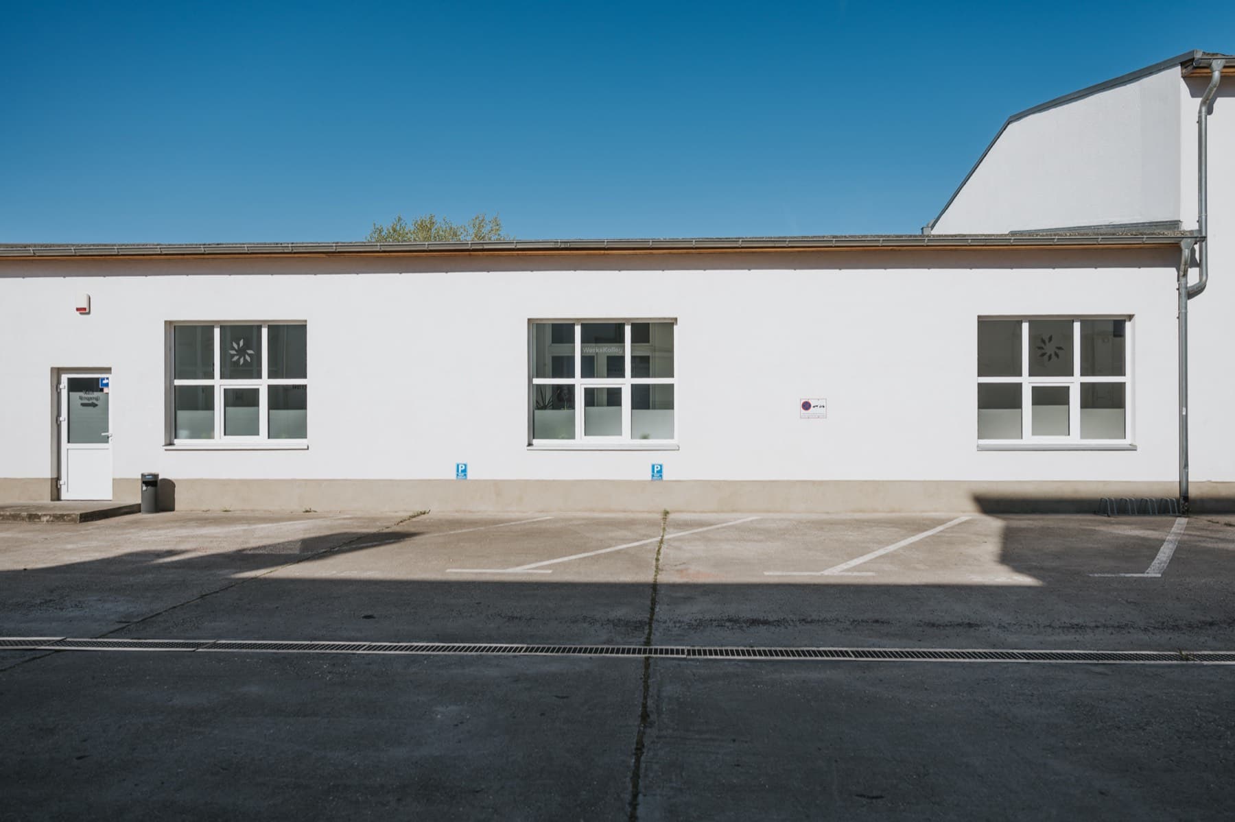 Lange Fassade der Halle 7 mit Parkplätzen