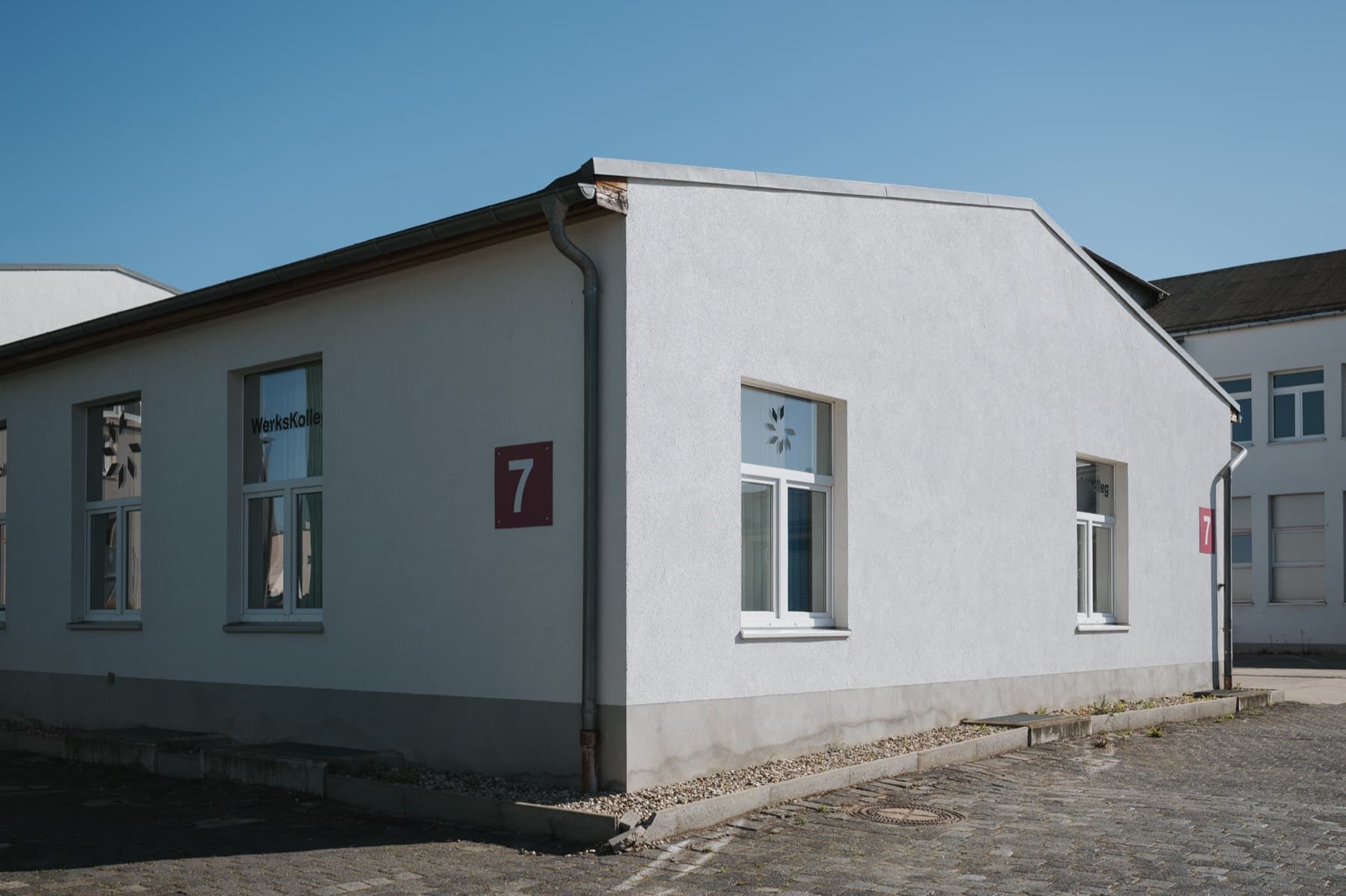 Gebäudeecke der Halle 7 mit zwei roten Hallenschildern